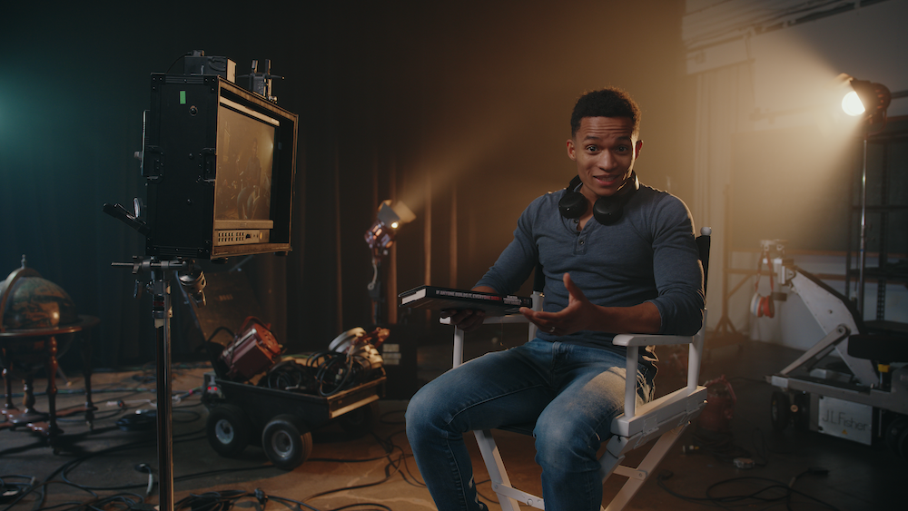 Still of Aric in a director's chair from the most recent video